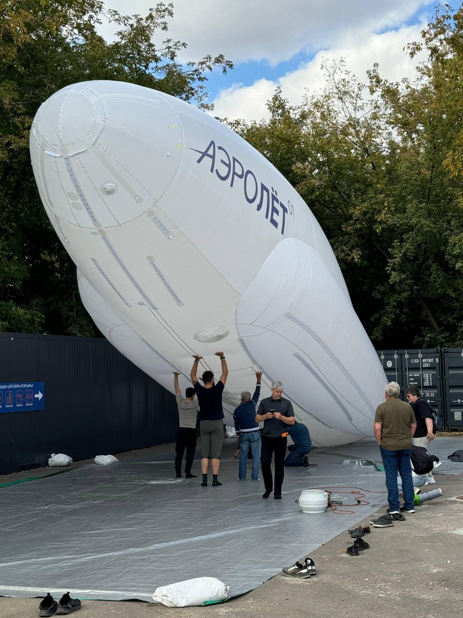 AEROLET-01 hybrid airship inflated outdoors, supported by the engineering team during a test.