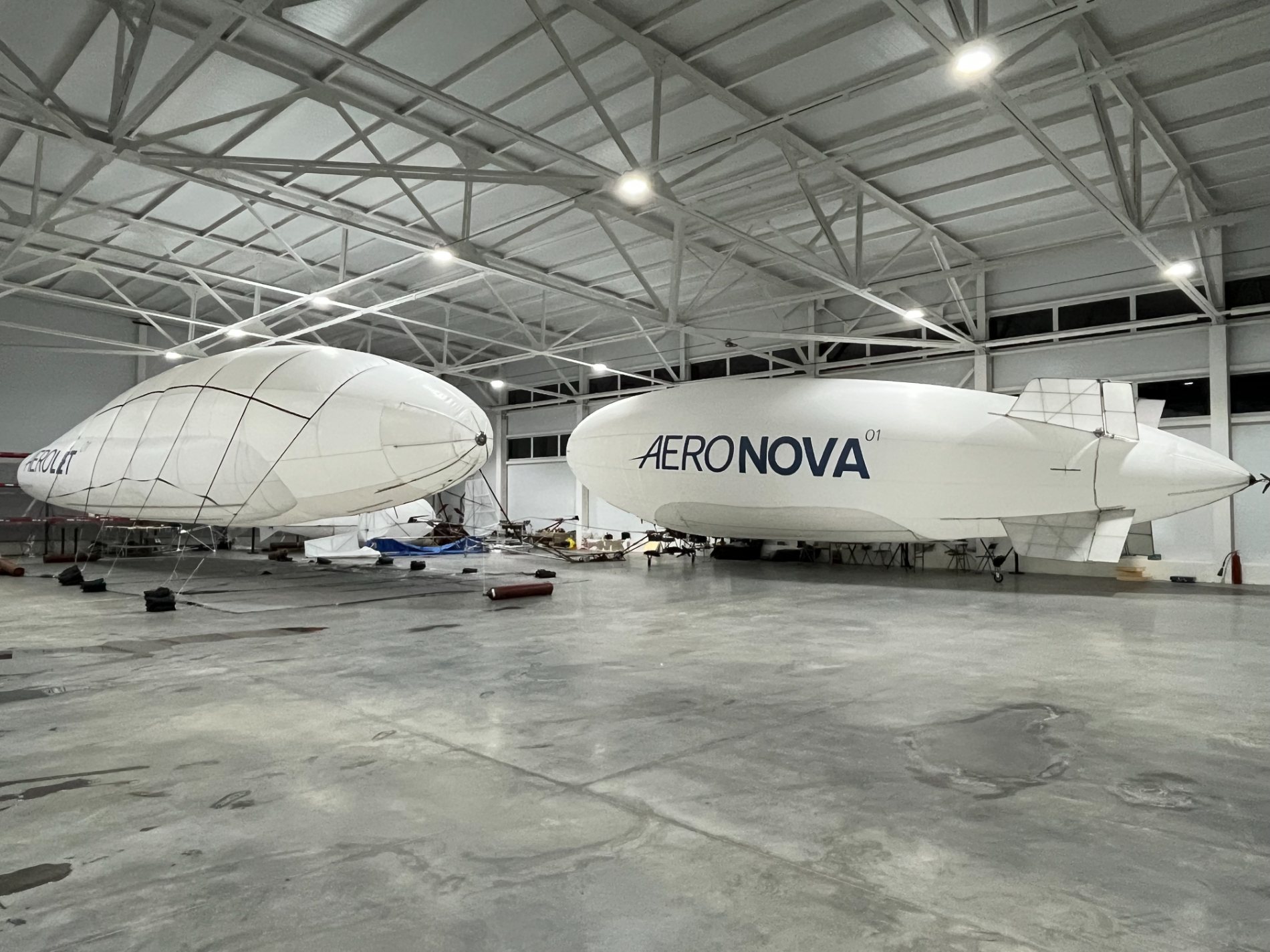 NOVA-01 and AEROLET-01 airships together inside the AERONOVA hangar.